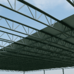 Looking up at steel joists half covered by roof deck.